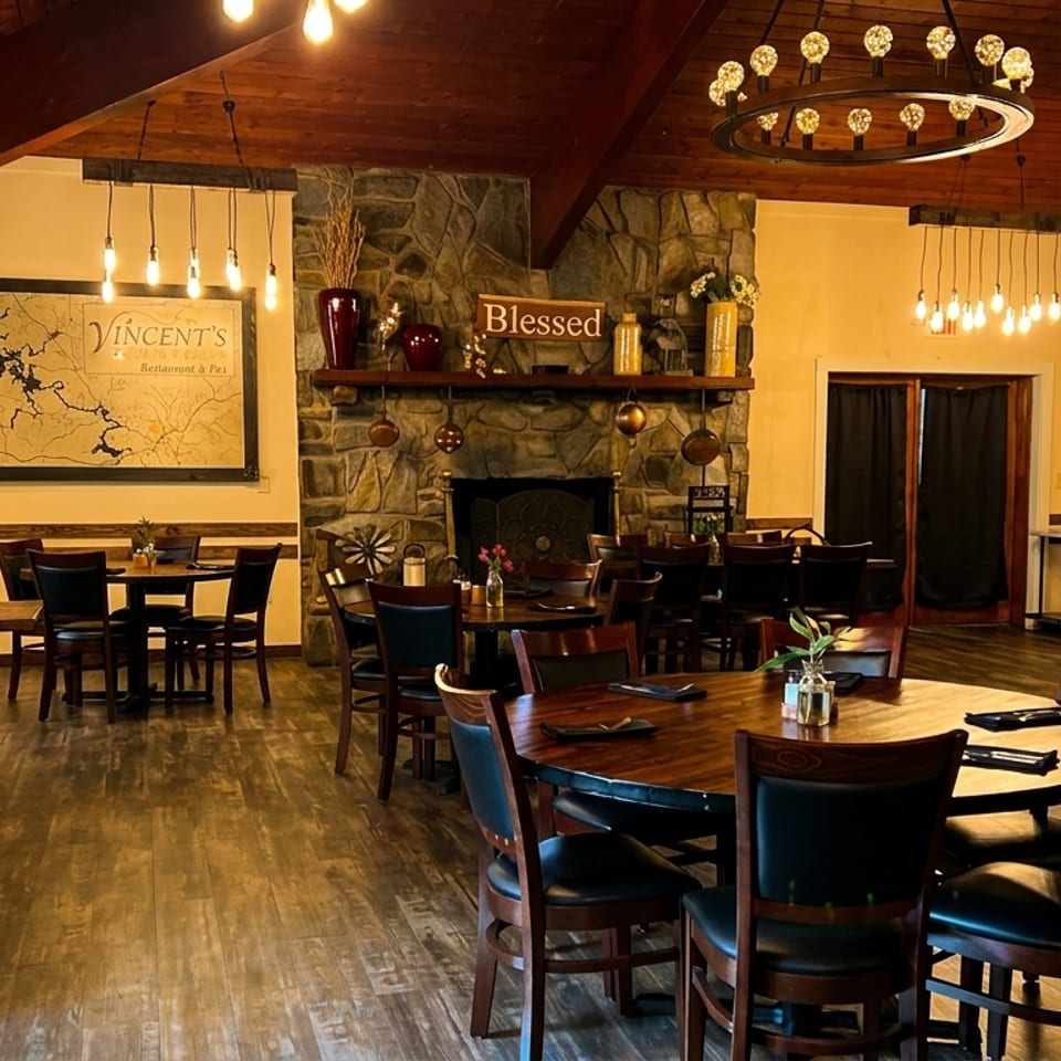 Vincent's Restaurant dining room with wooden tables, chairs, a stone fireplace, and map decor.